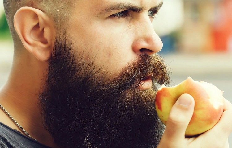 man with beard eating apple